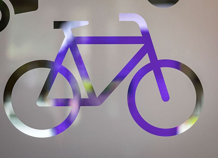 ADFC Fahrradklima-Test 2024 - Event - Fahrradsilhouette Lila Fahrradsymbol als durchsichtige Silhouette auf einer satinierten Glasfläche.